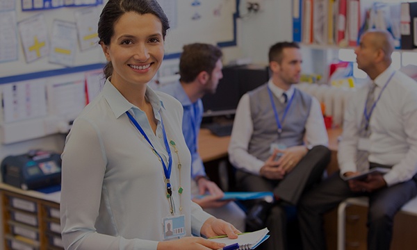 A woman smiling in front of her colleagues.